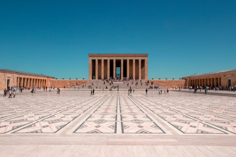 a large courtyard with two pillars and a number of people