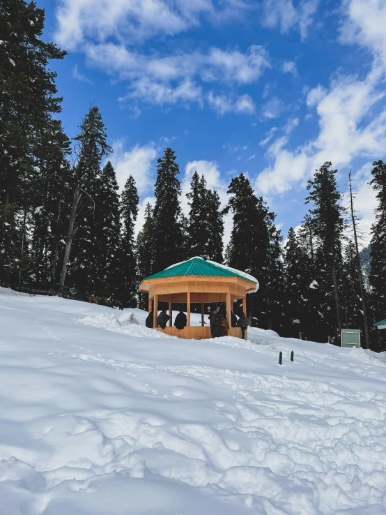 a gazebo sitting on top of a snow covered slope