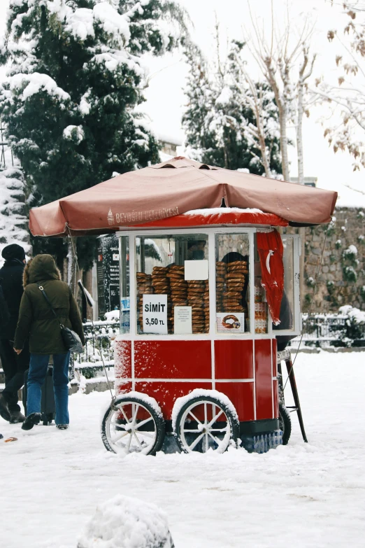 an orange and white cart some people and snow