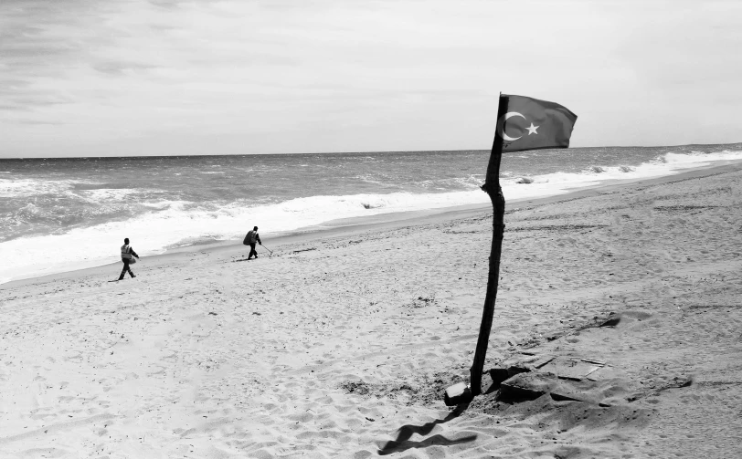 two people running along the beach with a flag