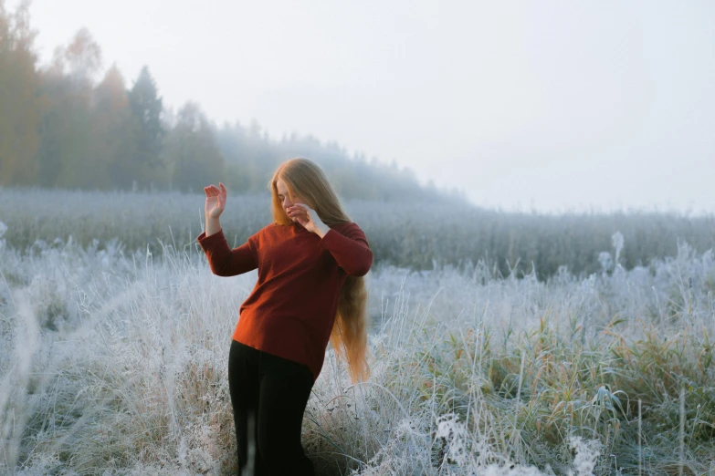 a beautiful woman in a red sweater holding her hands up