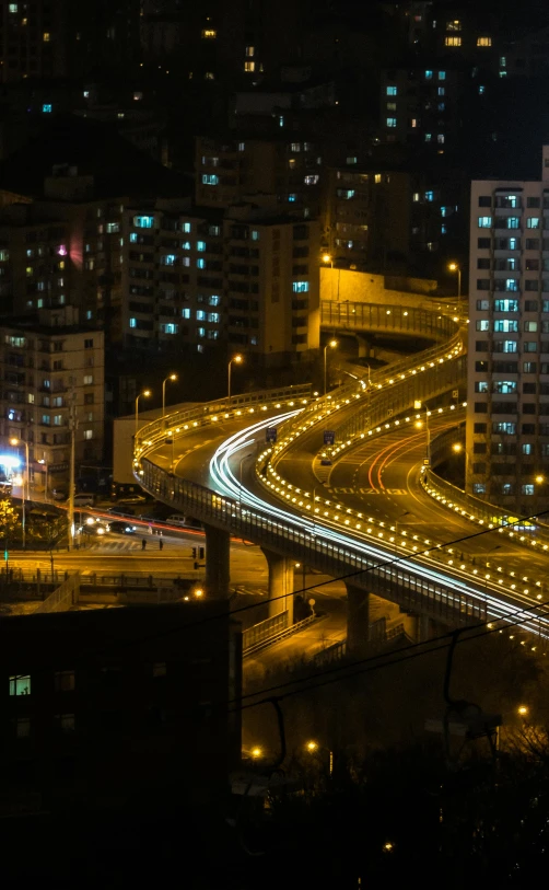 a nighttime view of a freeway with buildings and cars