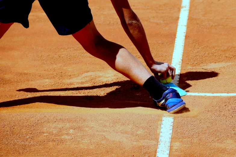 a tennis player bending down to swing his racket