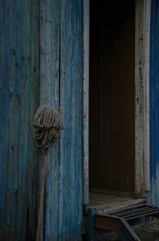 a broom with a scouring is next to a wooden wall