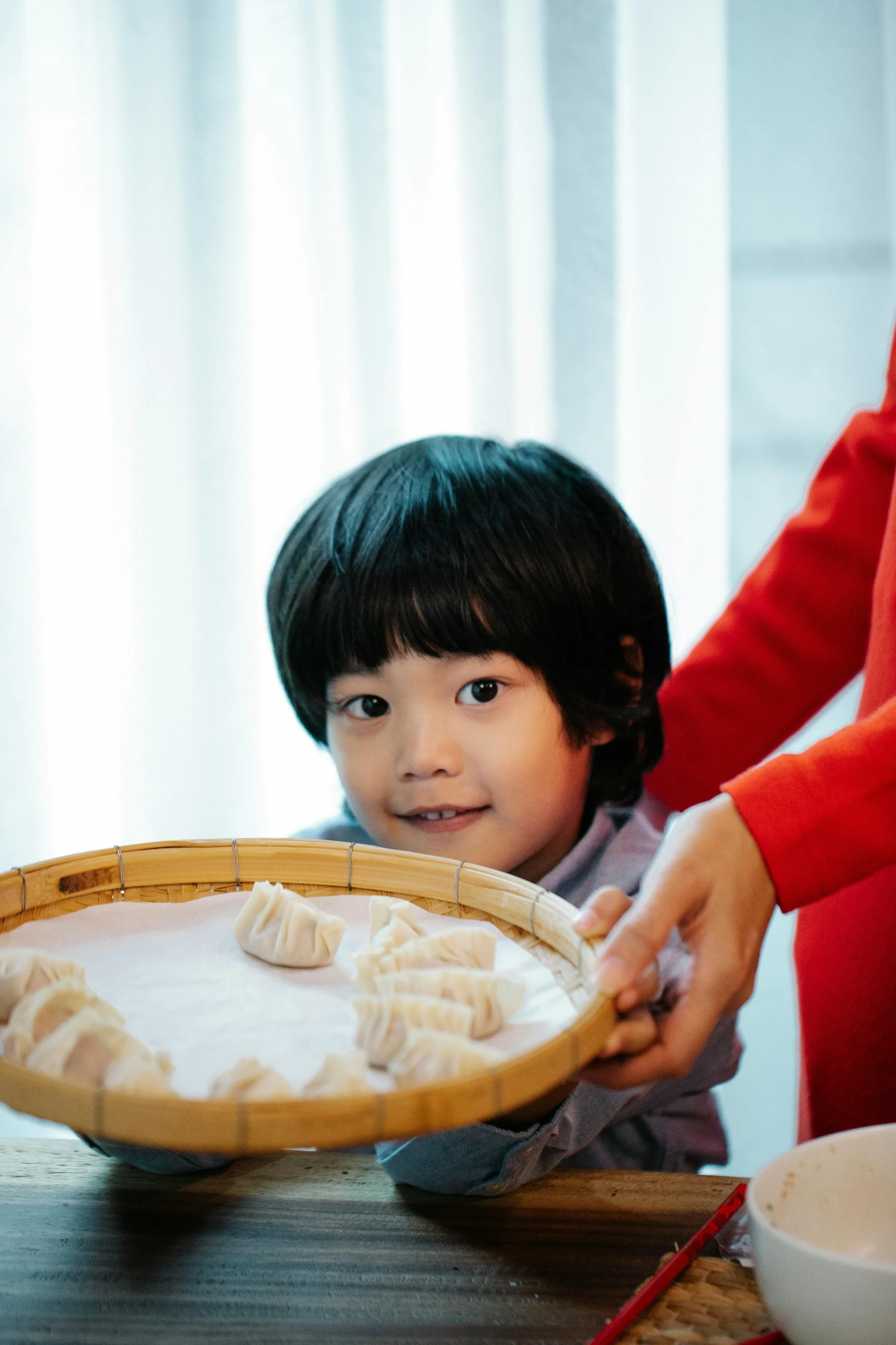 a little boy holding food in a wicker plate