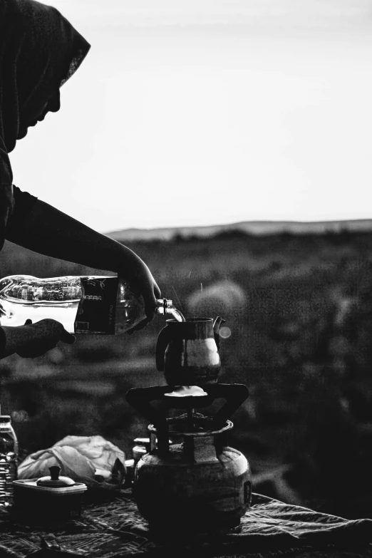 a man is pouring some water on a coffee pot