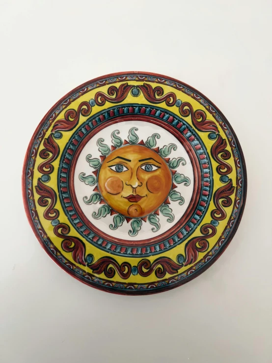 a decorative bowl has a face painted on it