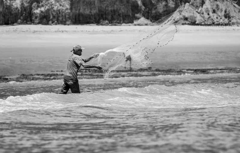 a young person kiteboarding at the beach on a cloudy day