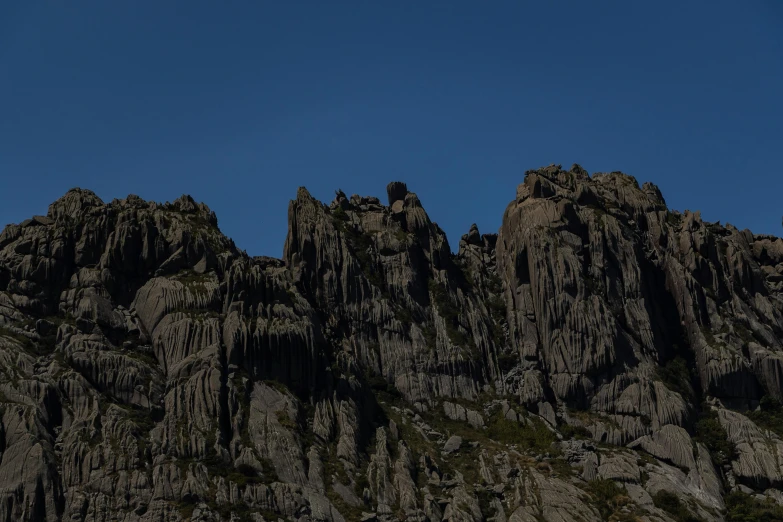 a plane flies over the top of some rocky mountains