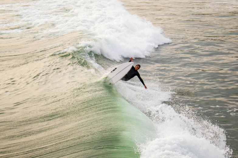 a person riding on a surfboard over a wave