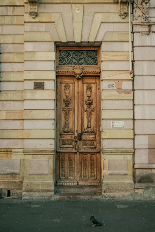 a wooden door that has a bird underneath