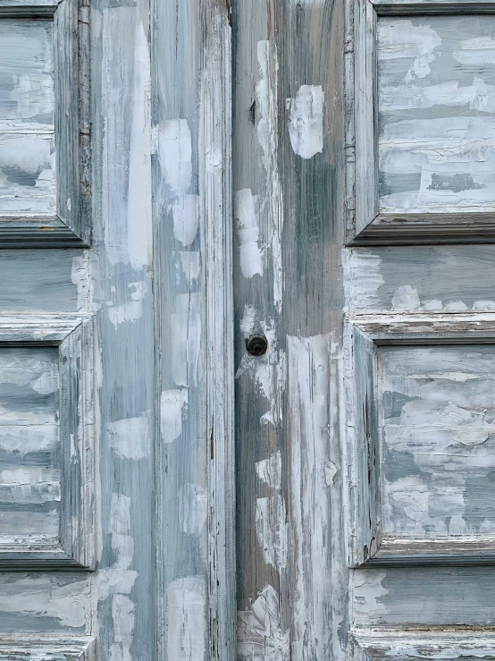 the door of an old, rusty building has peeling paint