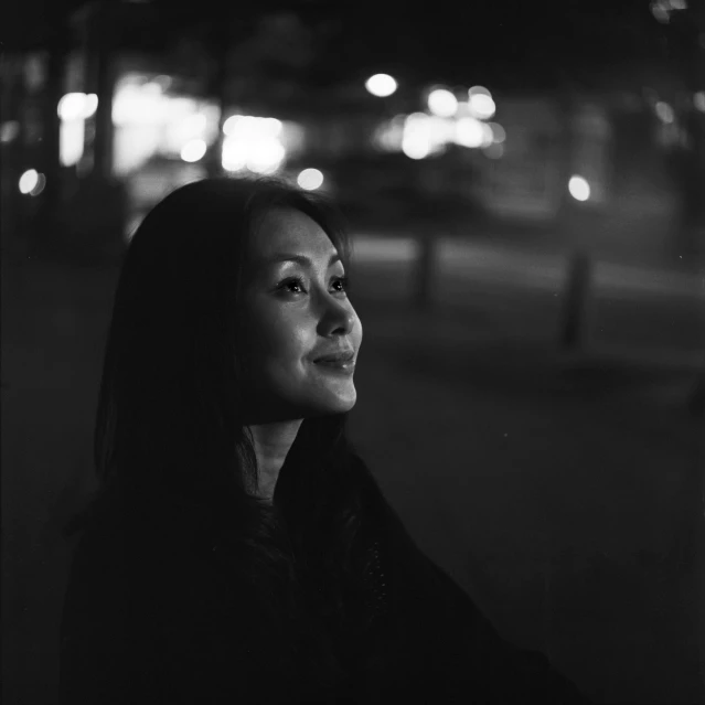 a woman is looking out the window at night