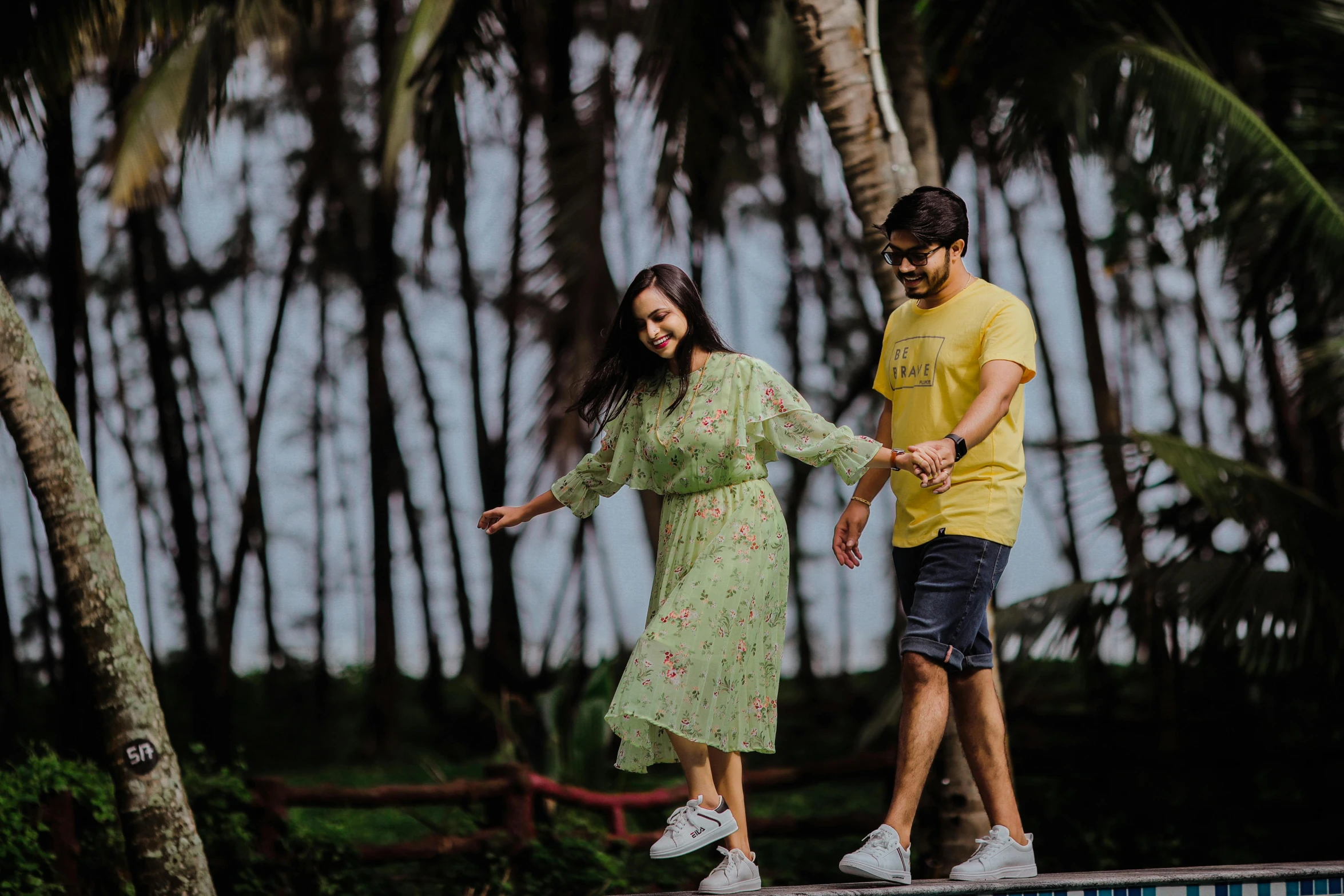 two people on a small platform near some palm trees