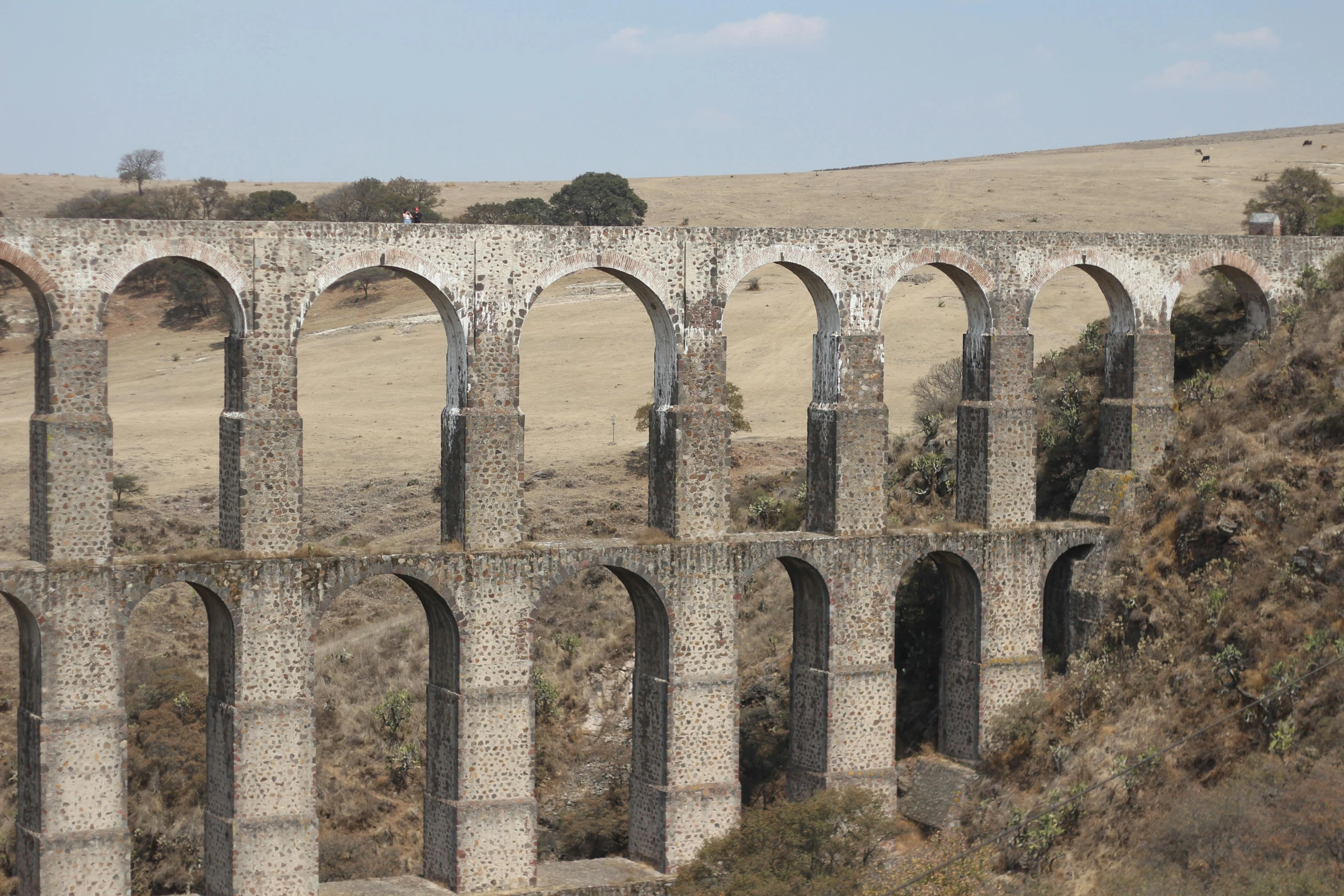 an old stone bridge in the middle of a field