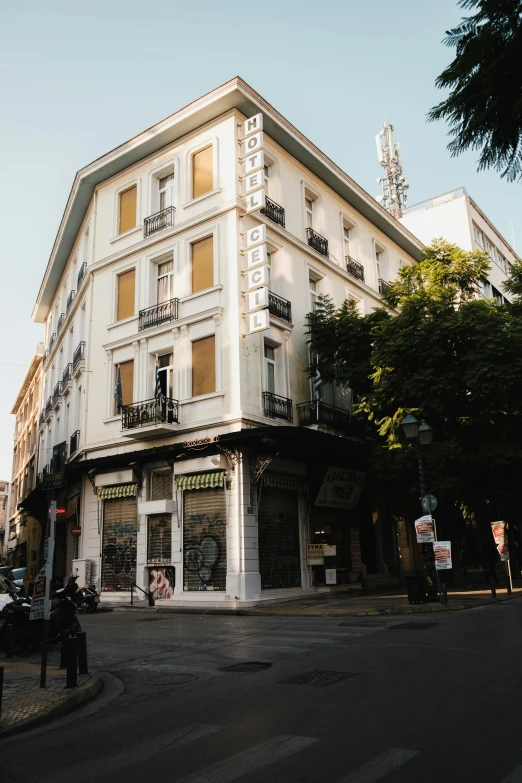 a white building is next to some green trees