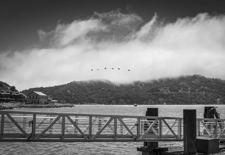 a pier with birds flying over the water