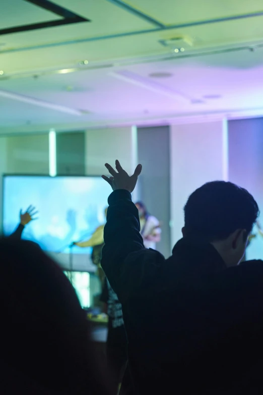 a crowd of people standing and watching a television