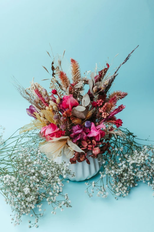 a white flower vase filled with red flowers