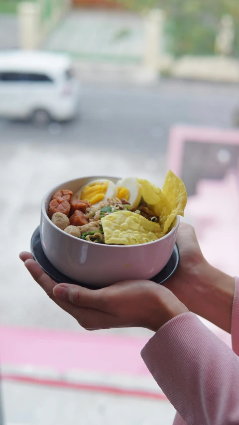 a person holding up a plate of food