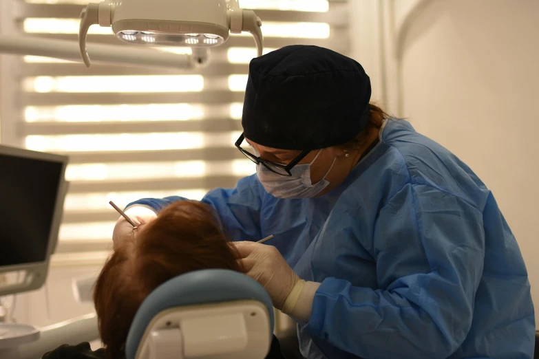 a woman in a dentist's office working on an orca