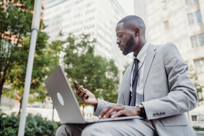 a man with a laptop on a park bench