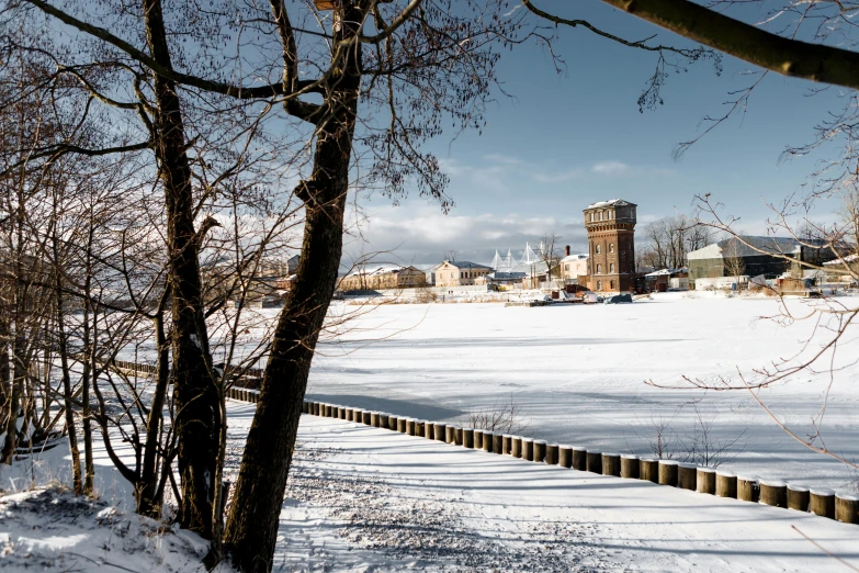 a building standing on a snowy field with many trees