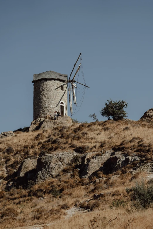 an old fashioned windmill on a dry hillside