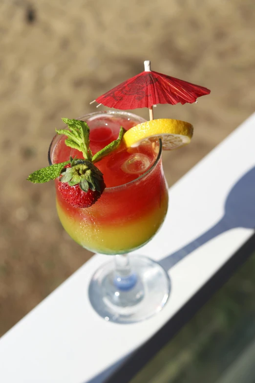 a glass of a red and yellow beverage sits on a table