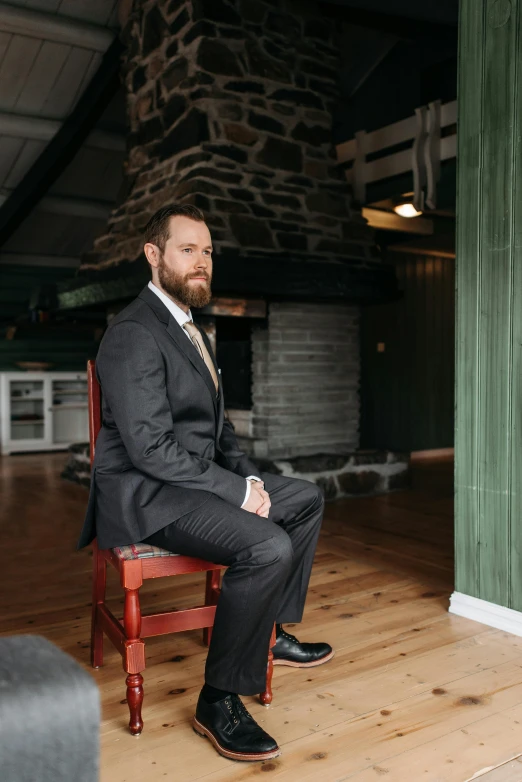 a man sitting in a chair wearing a suit