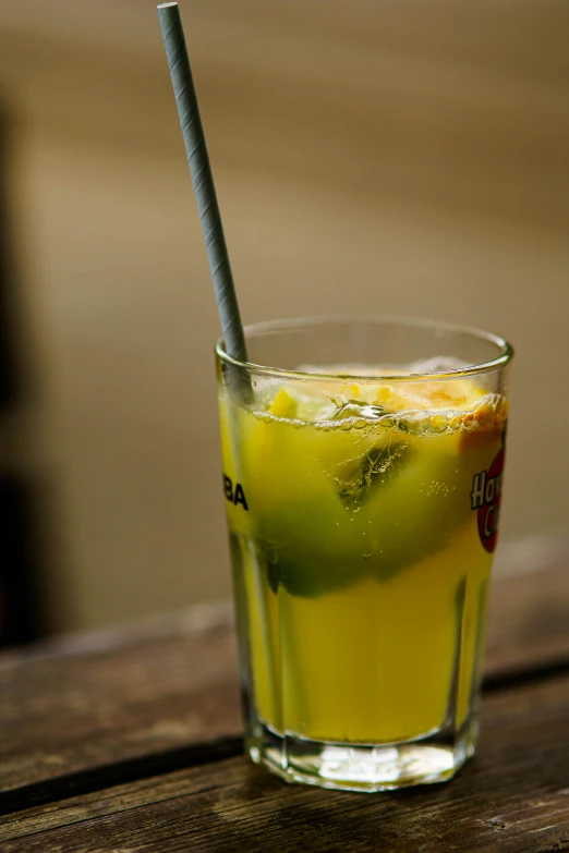 a glass on top of a wooden table filled with lemonade