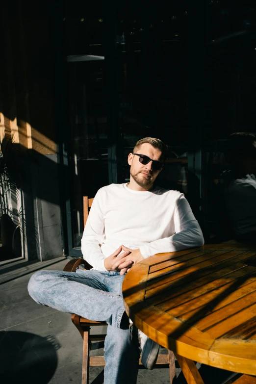 man sitting at table looking down in the dark