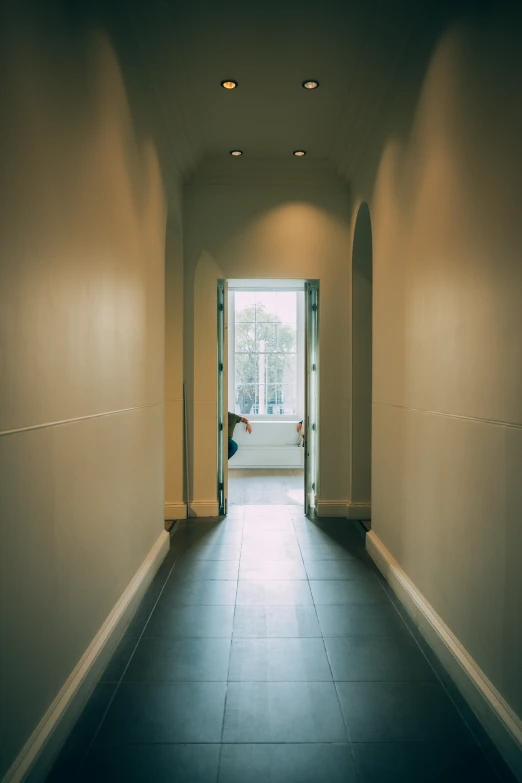 a long hallway with an open door leading to a nice room