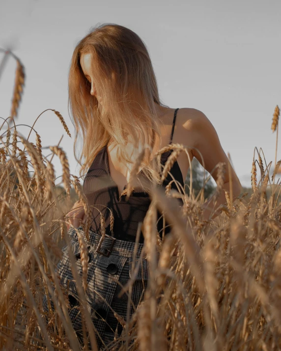 a woman sitting in the middle of a wheat field