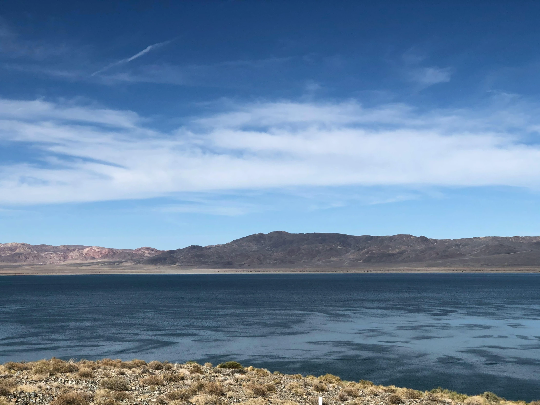 a body of water with a hillside in the background