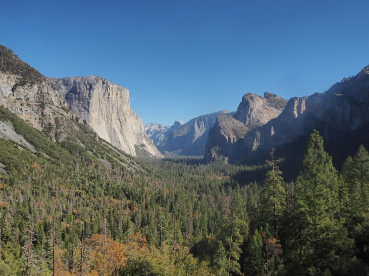 an overview of a mountain valley with forest in the background