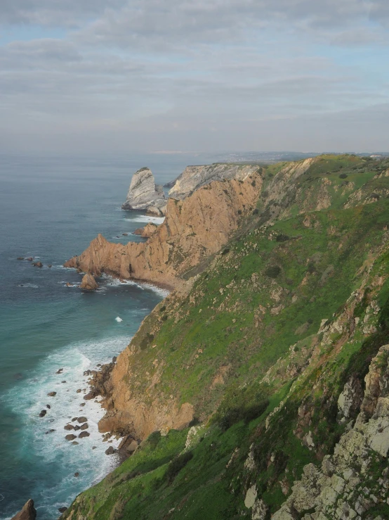 the ocean has an island and several cliffs along it