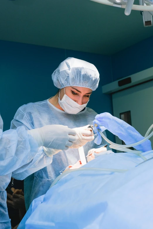 two surgeons in scrubs perform  on a large patient