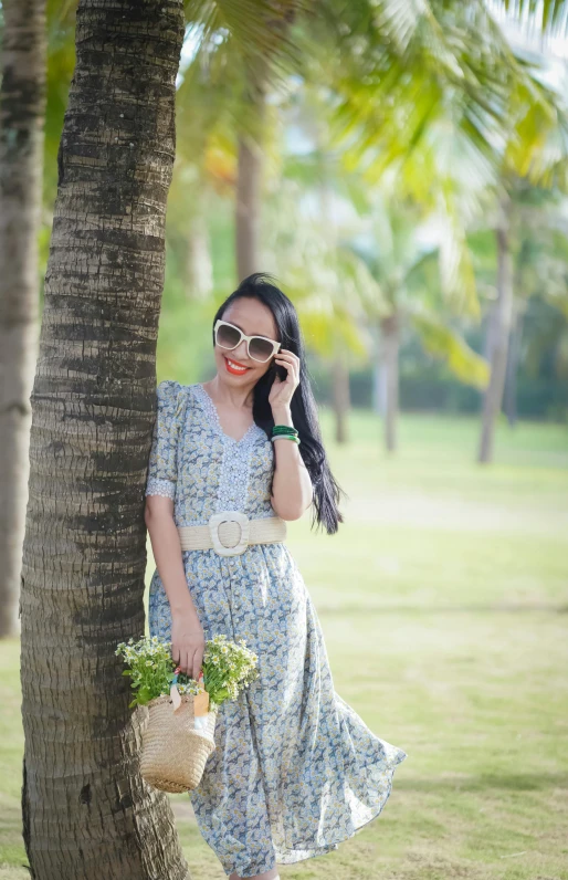 a woman with long hair standing next to a tree