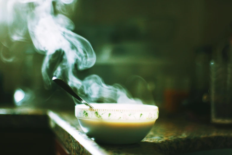 a steaming soup bowl is on a kitchen counter