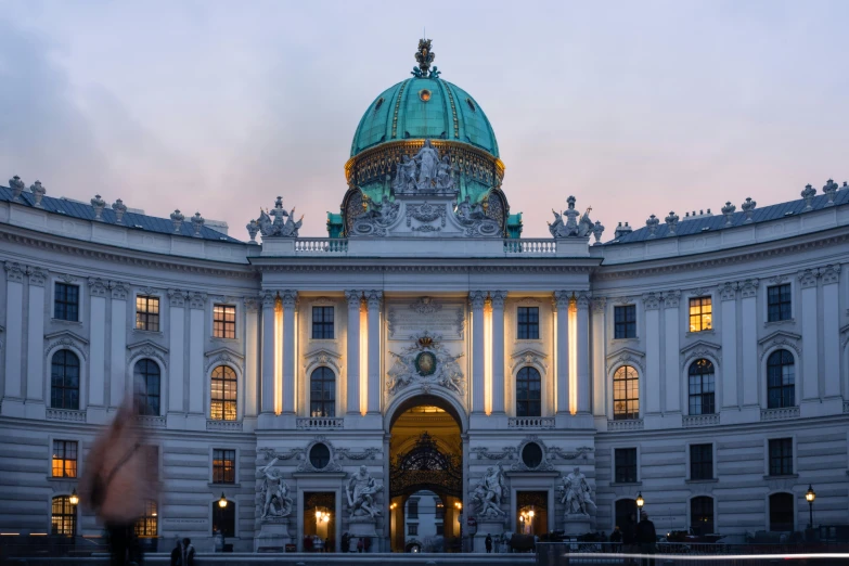 a white building with a green dome and light columns