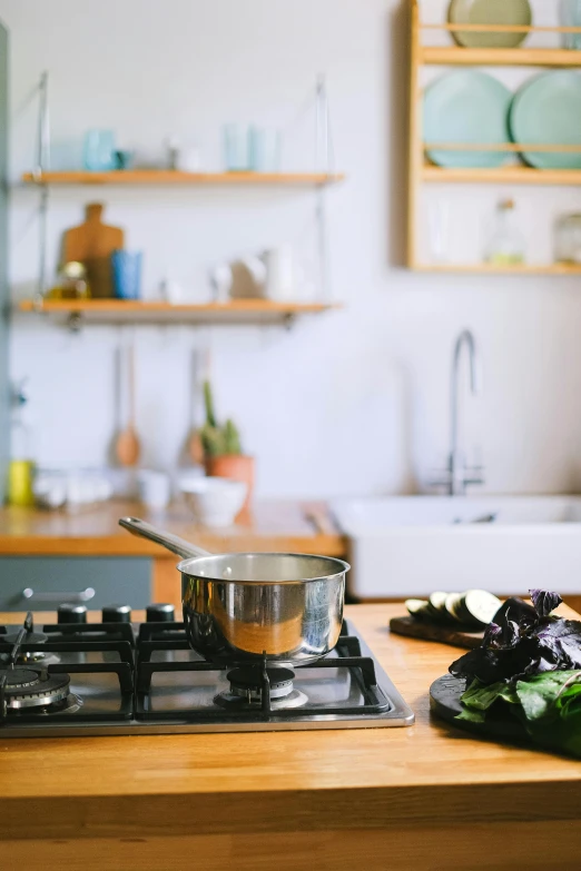 a metal pot is sitting on a gas stove top