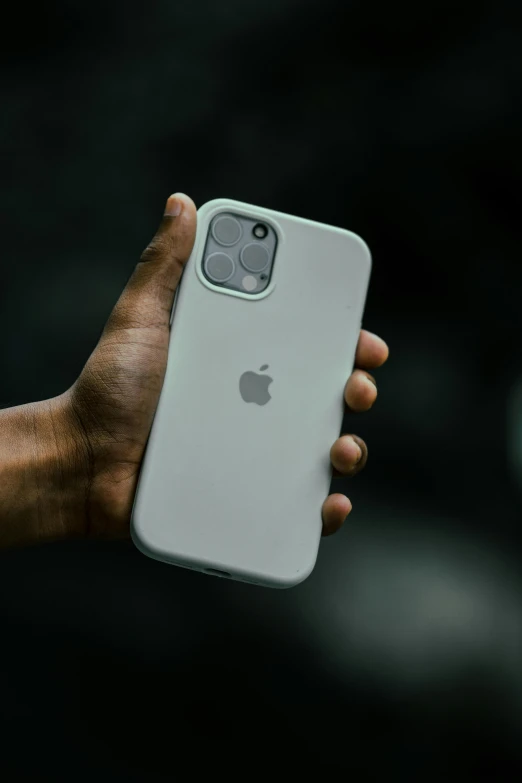 a person holding an apple iphone 12 in their hand