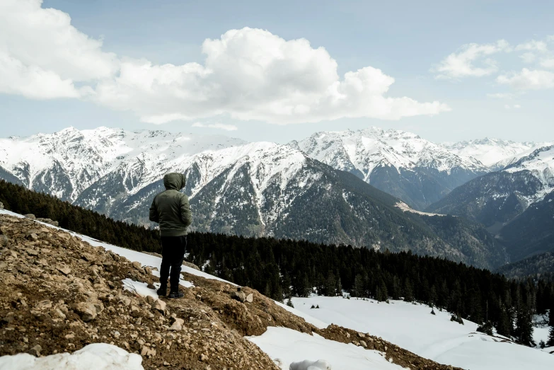 a person overlooking mountains from atop a snowy mountain