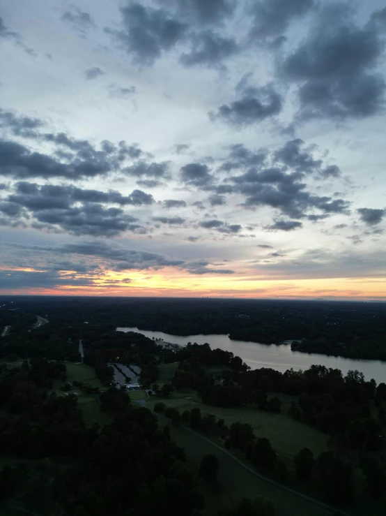 an aerial view of a lake and countryside at sunset