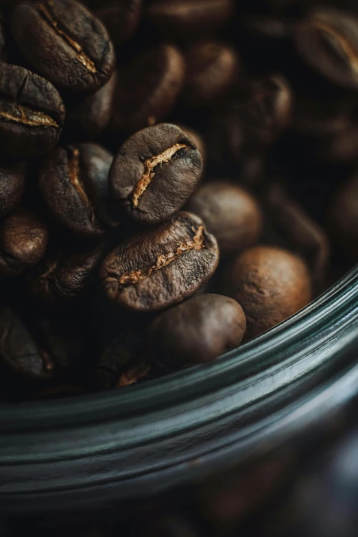 a close up of a jar filled with coffee beans