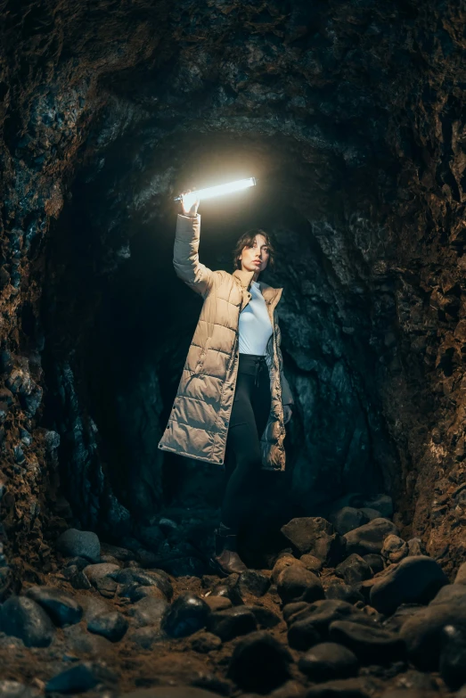 a person holding a light inside of a tunnel