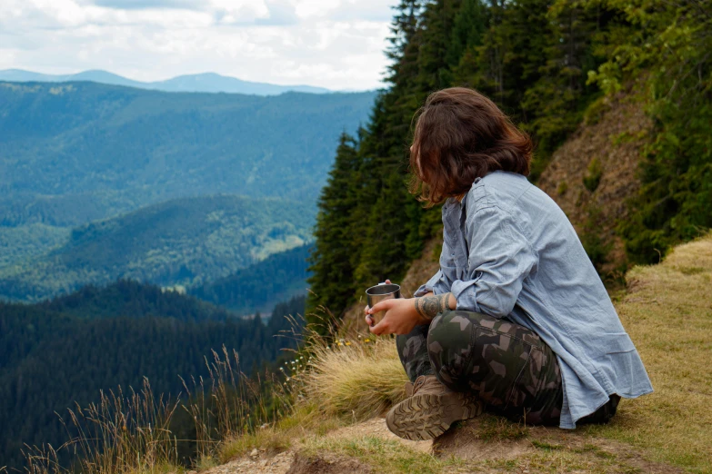 a person on top of a hill looking at the scenery