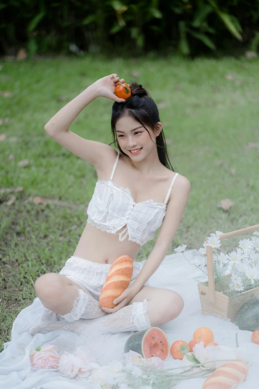 a woman sitting on a blanket holding a piece of fruit