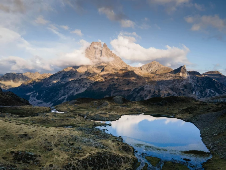 a large mountain sits in the distance with a small body of water